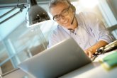 Office worker with headset on while having video conference Büromitarbeiter mit Laptop und Headset